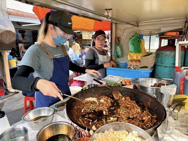 Hawker tossing Char Kway Teow in the wok at Restoran 77 Food Yard